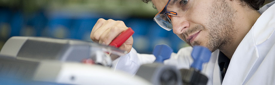 Una persona trabajando con bata blanca y gafas protectoras